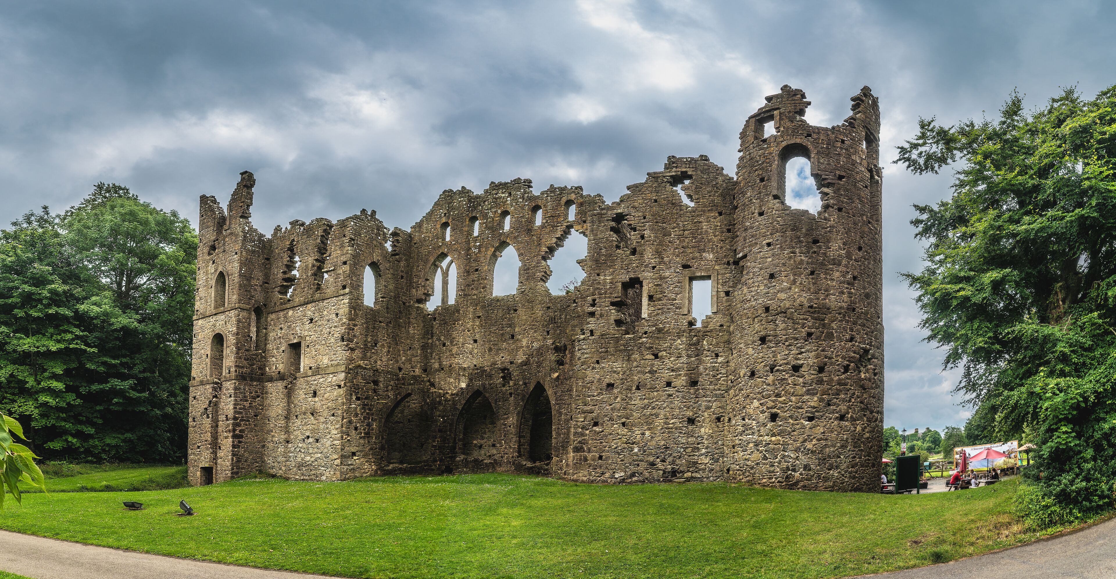 A historic stone castle ruin surrounded by lush greenery.