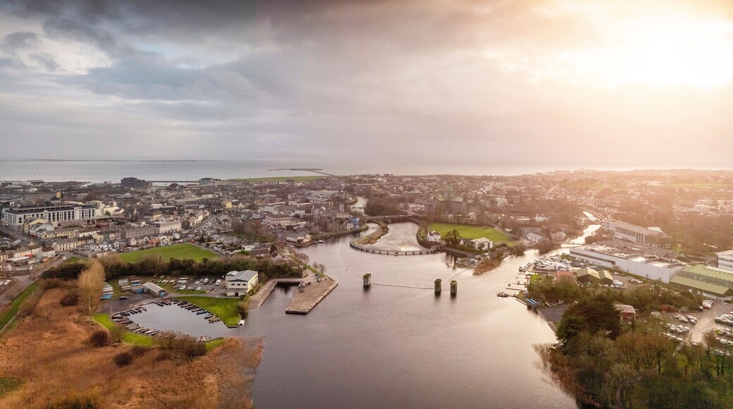 Aerial drone view on Galway city. River Corrib and rowing club. Dark dramatic sunset sky. Nobody. Popular tourist and business city with rich history.