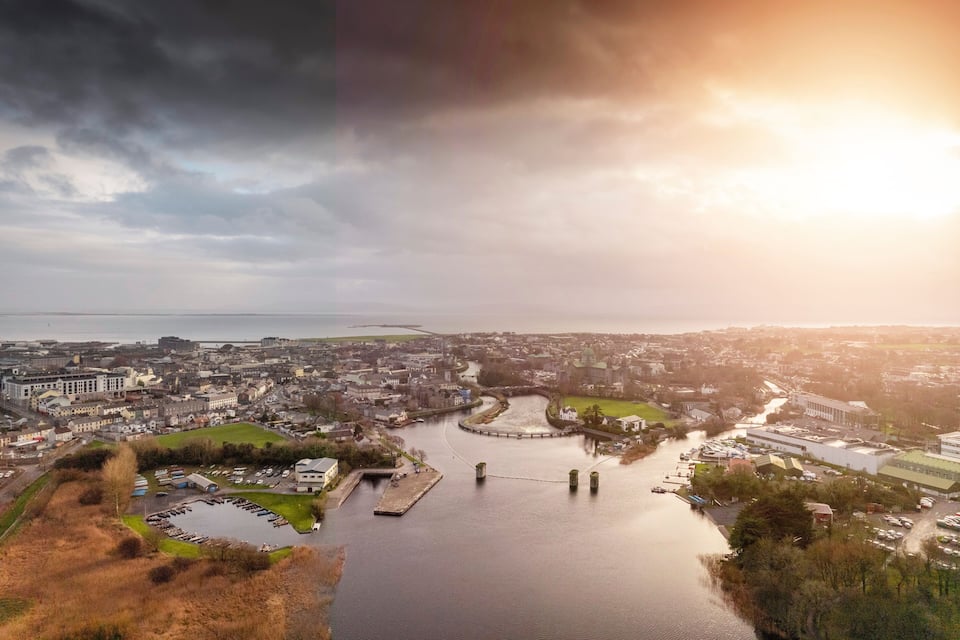 A river flowing through a town with buildings and a bridge.