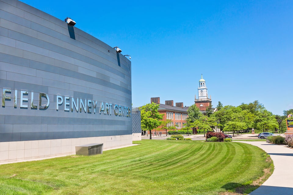 The Field Penney Art Center building with a clear blue sky and a distant clock tower.