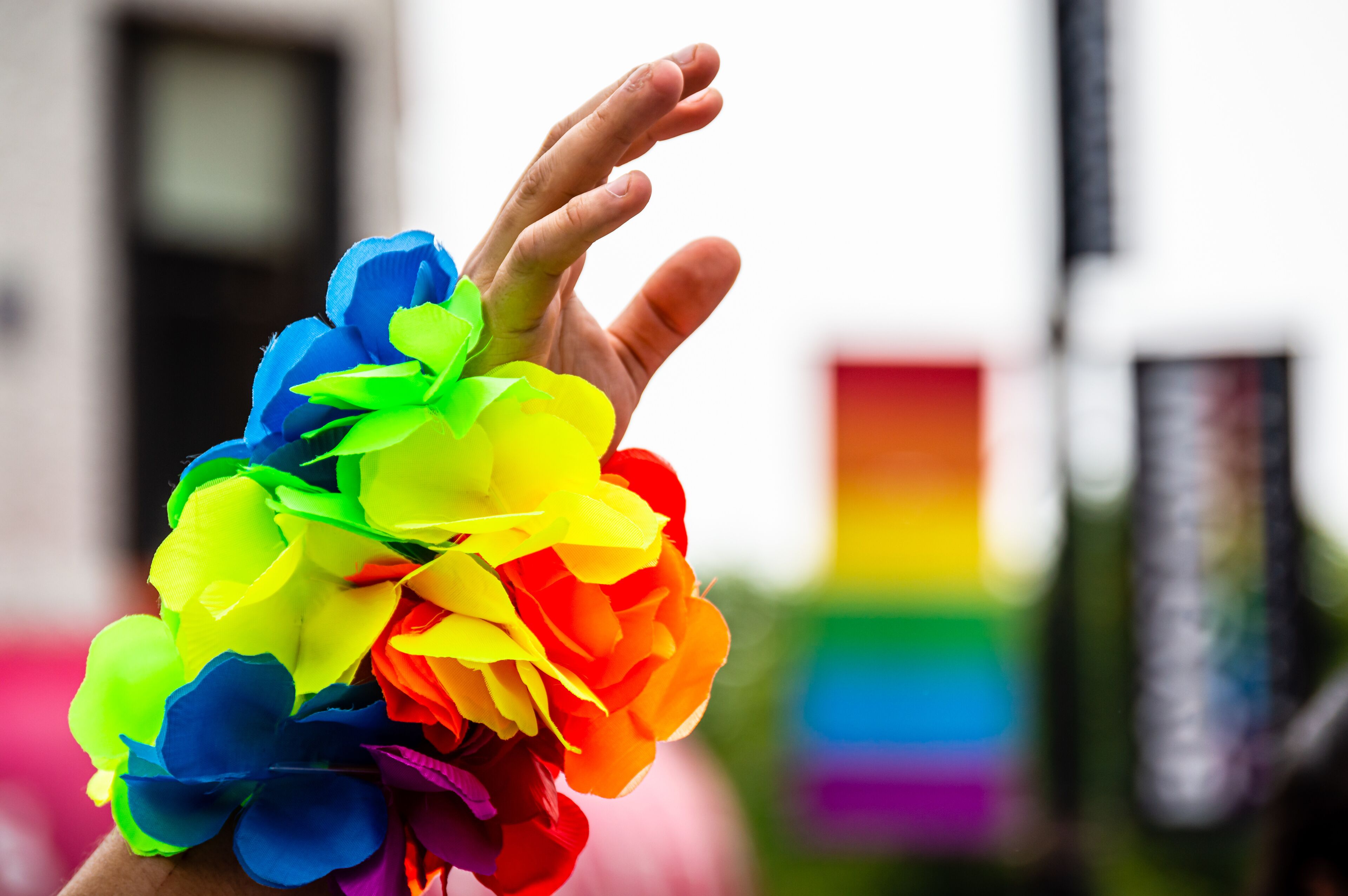 A man&#x27;s hand is waving in the air and wearing a rainbow bracelet at Gay Pride parade.