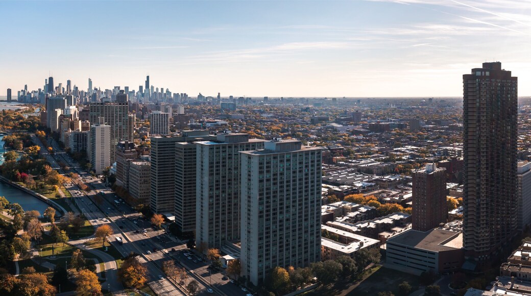 Beautiful cityscape aerial panorama of the Lakeview neighborhood lakefront with autumn foliage surrounding Belmont Harbor and the Chicago skyline in the distance on a sunny day.