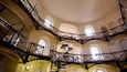 A multi-level iron staircase with arches and windows in a building.