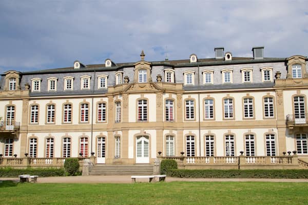 Ein großes, verziertes Gebäude mit zahlreichen Fenstern und einem zentralen Eingang.