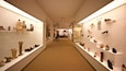 Un couloir de musée où des chaussures sont exposées de part et d’autre.