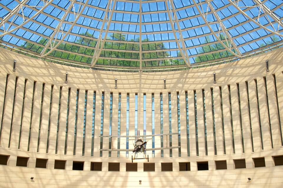 A modern building with a glass dome and a drone flying inside.