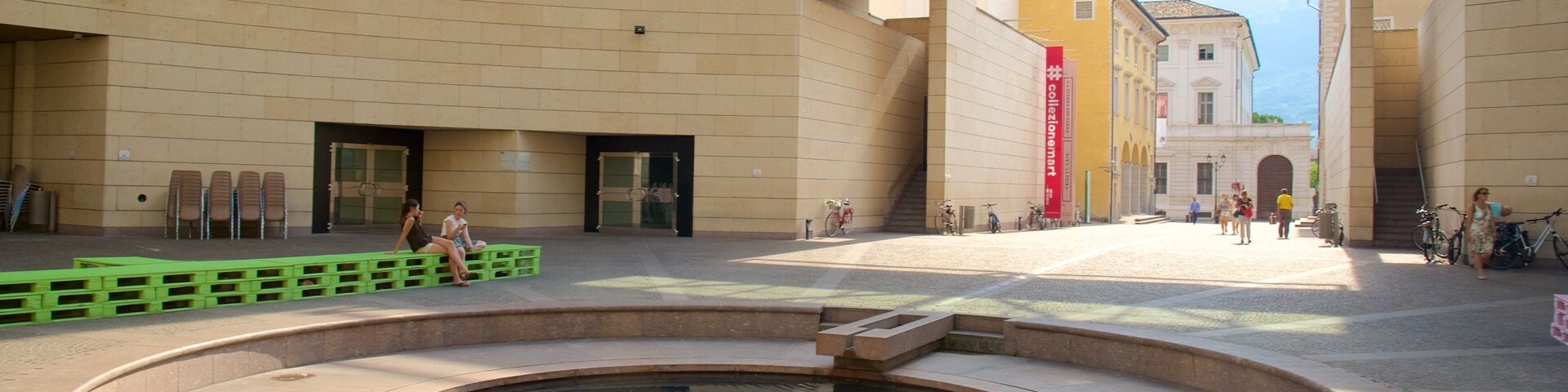 Museum of Modern and Contemporary Art showing a pond and modern architecture as well as a small group of people