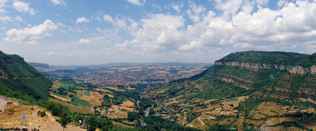 A valley with a town, green hills, and a river.