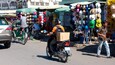 A street market with various stalls selling hats and other items.