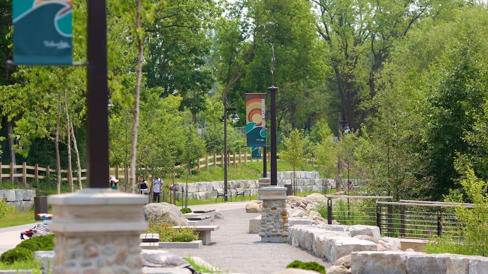 A park pathway with stone pillars, a wooden fence, and a sign for 'Willemstad'.