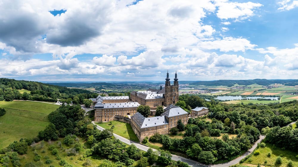 A castle surrounded by lush green hills and a clear blue sky.