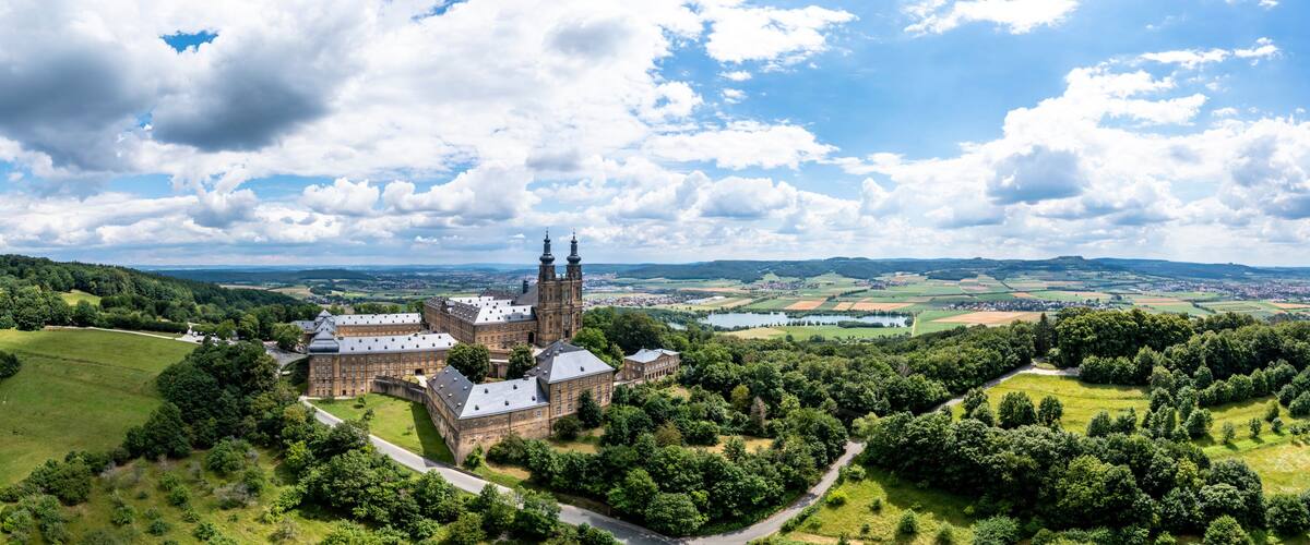 A castle surrounded by lush green hills and a clear blue sky.