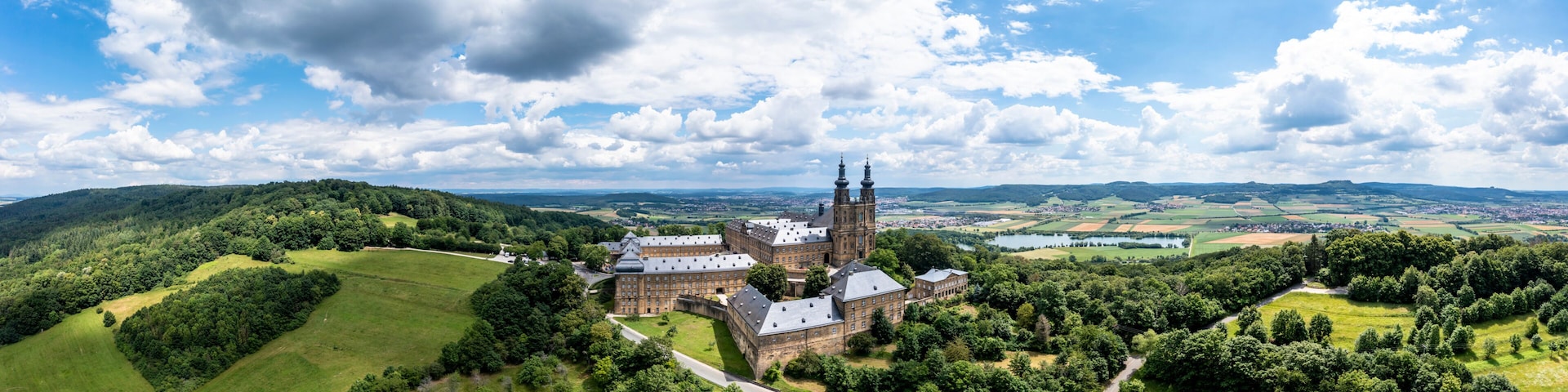 A castle surrounded by lush green hills and a clear blue sky.