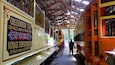 Un tren panorámico antiguo con un cartel que anuncia un recorrido de 16 kilómetros alrededor de dos montañas.