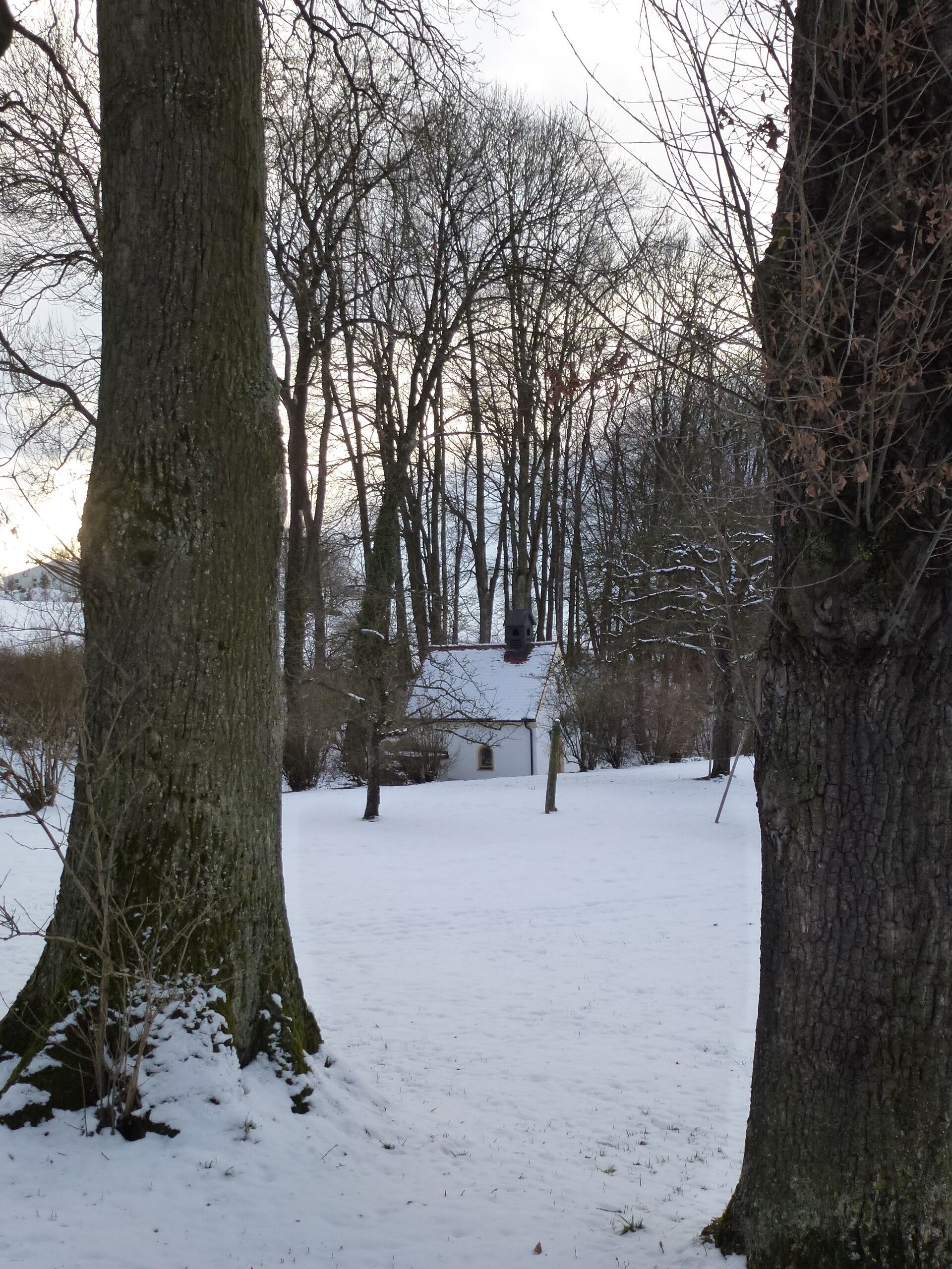 Bergkirchen -OT Kreuzholzhausen Grottenweg- moderne Marienkapelle mit kleiner Glocke und Grotte im Lourdes-Stil. Im Inneren ein gerahmtes Bild "Die Lourdesgrotte mit Josephshort und Marienheim in Kreuzholzhausen (bei Dachau)", signiert "Schemminger 1890", sowie zahlreiche Devotionalien. Ansicht aus NO