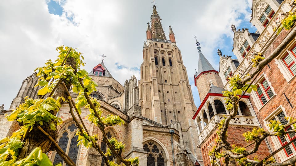 A historic church with intricate architecture, including a tall spire and detailed brickwork.