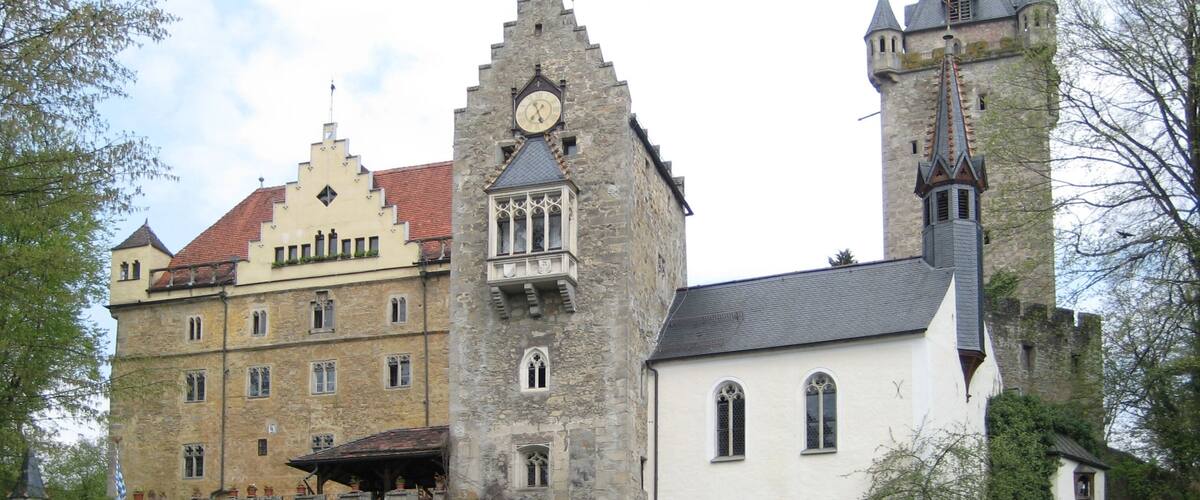 A historic building with a clock tower and a church.