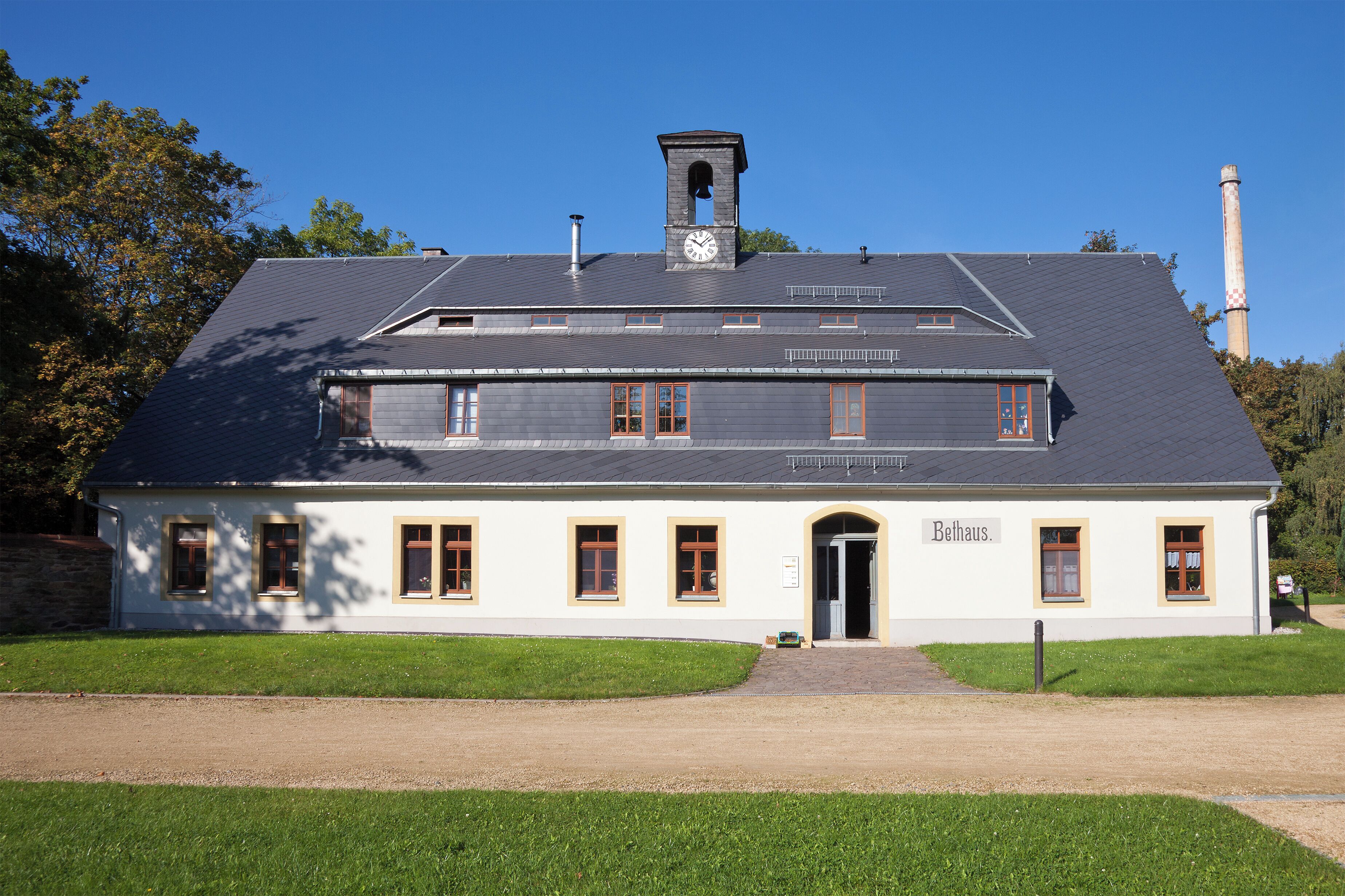 A white building with a clock tower and the name "Bethaus" on the front.