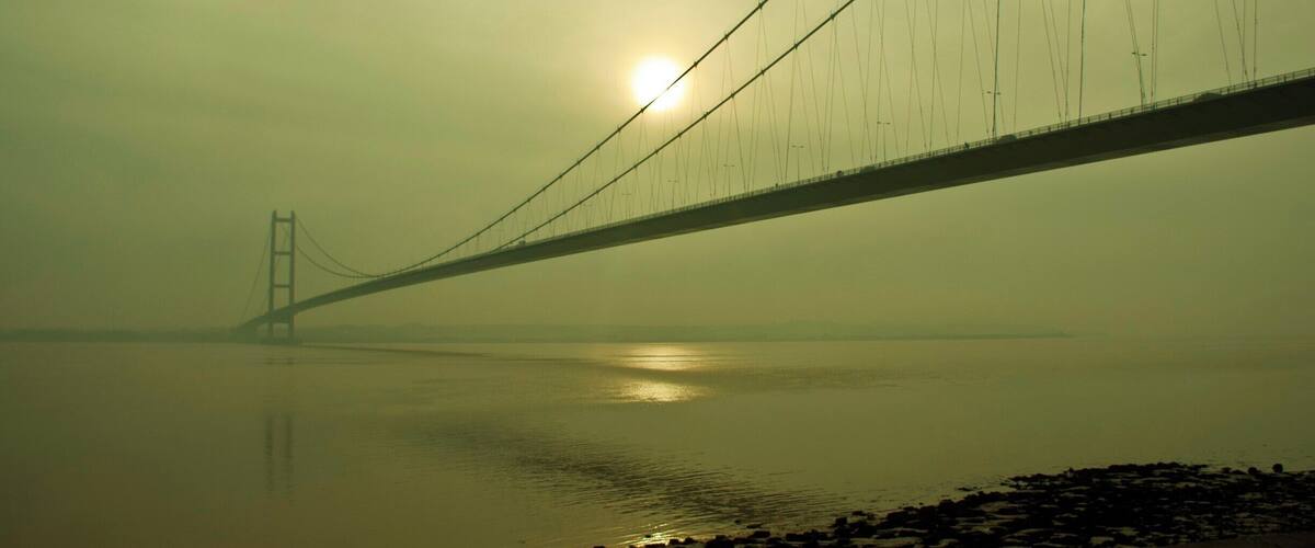 A bridge over a body of water with a hazy sky.