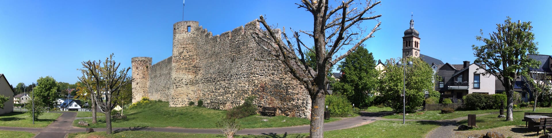 Medieval city wall with round towers and church in the old town of Hillesheim, Eifel region in Germany