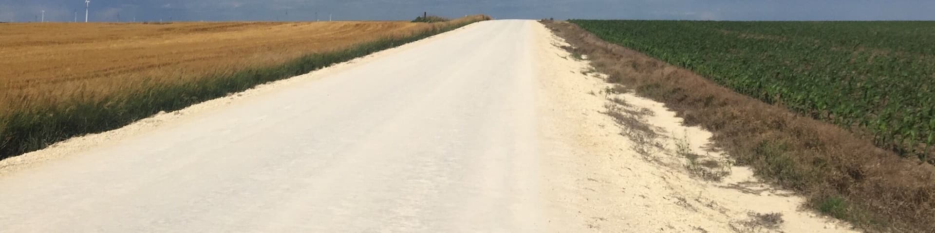 Peaceful country in western Kansas. Limestone roads with golden wheat on one side and green corn on the other.