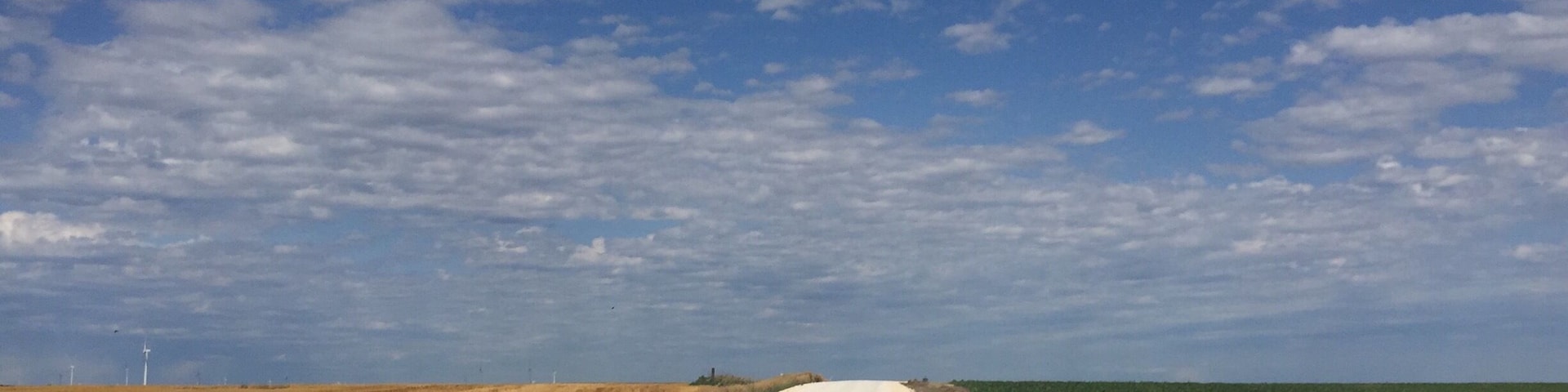Peaceful country in western Kansas. Limestone roads with golden wheat on one side and green corn on the other.