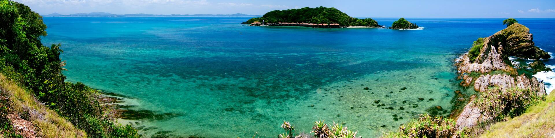 panorama view from hill top at Kapas Island, Terengganu, Malaysia surrounded by crystal clear water, coral, island and blue sky background.