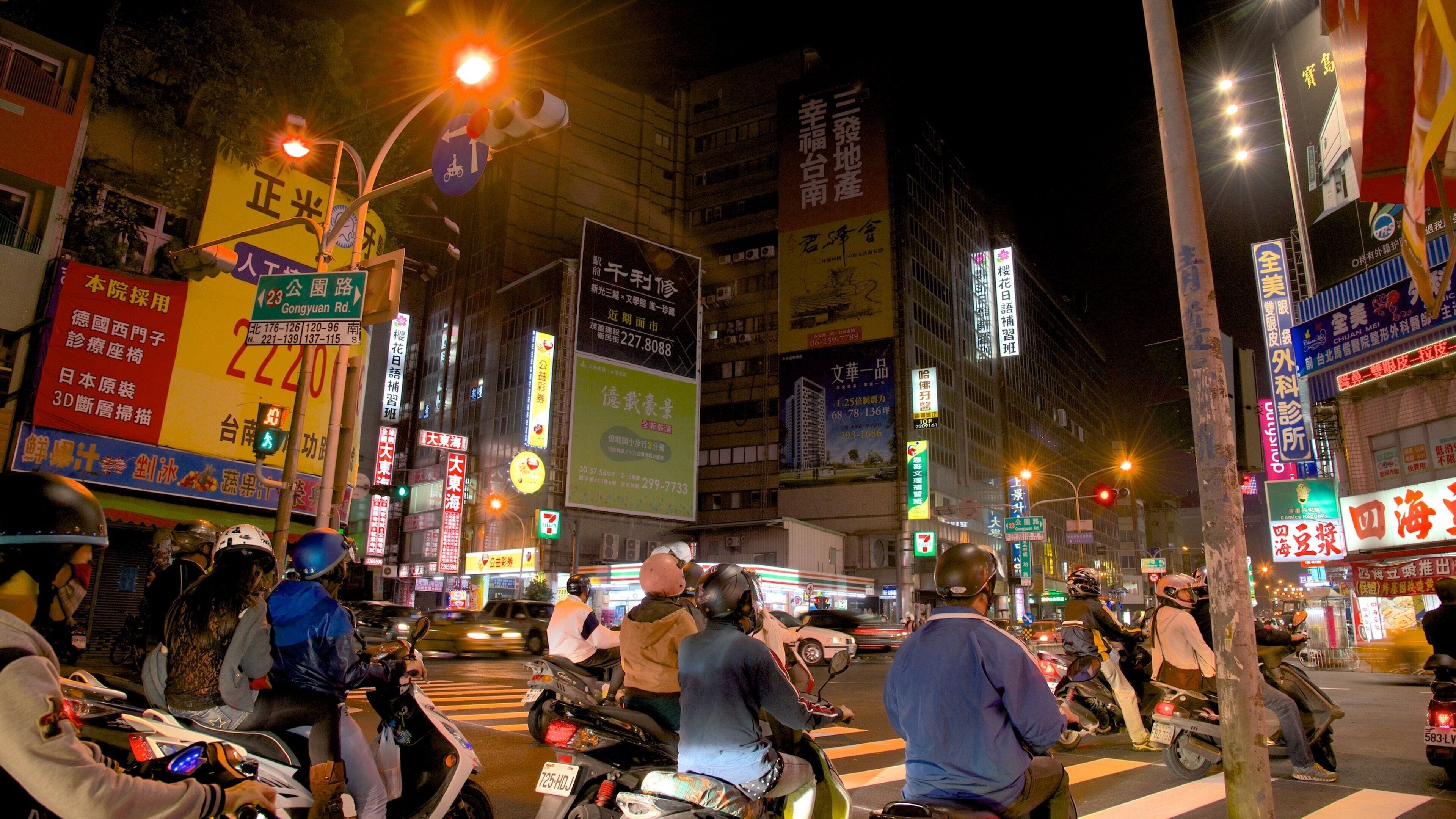 Tainan featuring night scenes, motorbike riding and a city