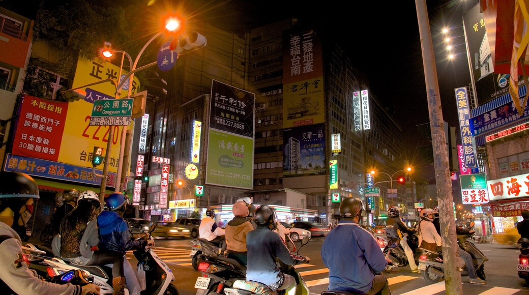 Tainan featuring night scenes, motorbike riding and a city