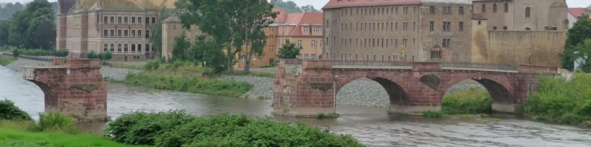 Un puente de piedra sobre un río, flanqueado por edificios históricos.