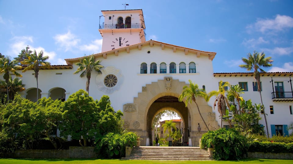 A historic building with a clock tower, arched windows, and a central archway.