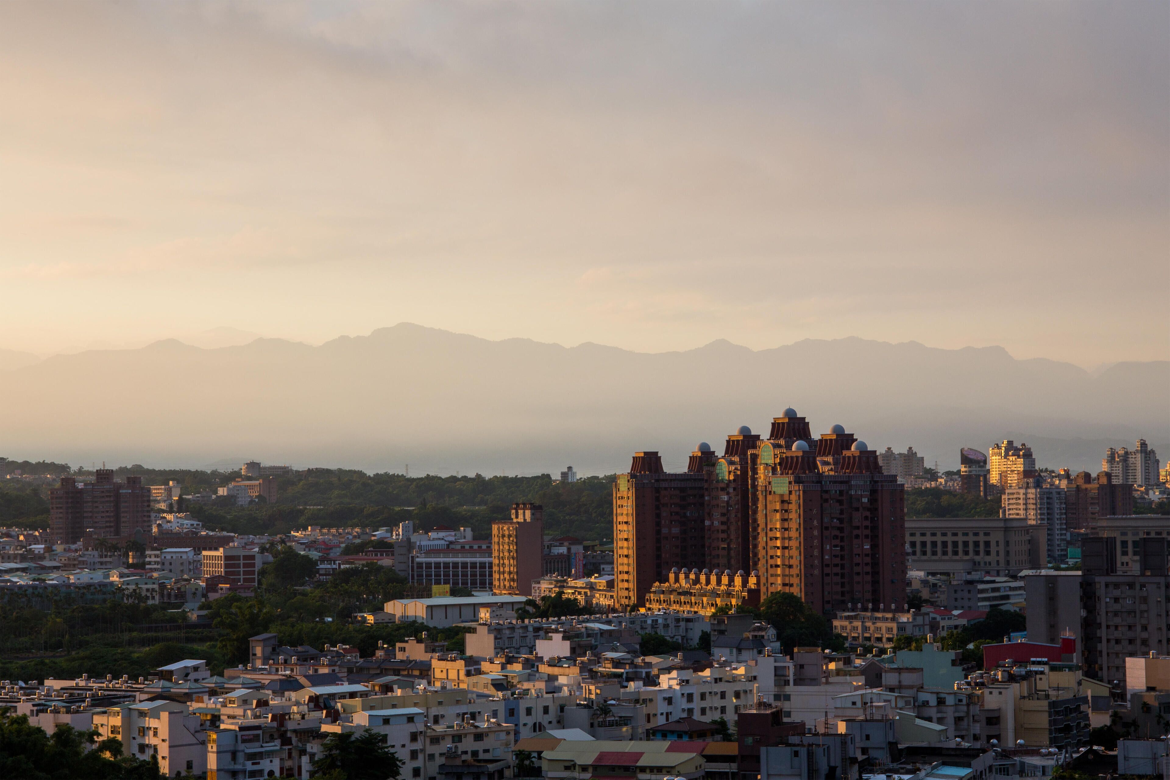 FAH78N The sun rising over the city of Chiayi with mountains in the background