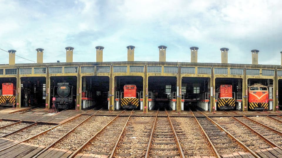 Een treinstation met meerdere sporen en treinen.