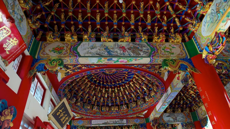 A richly decorated temple interior with ornate golden statues, vibrant murals, and intricate architectural details.
