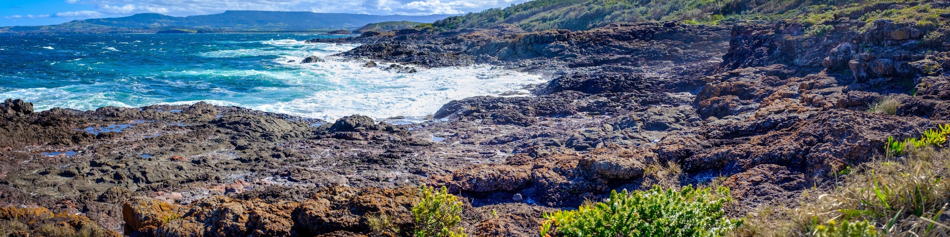 Panorama view from Bass Point Reserve across Pacific Ocean to Mystics Beach on Minnamurra and spit with Saddleback Mountain in distance, Shellharbour, New South Wales Australia