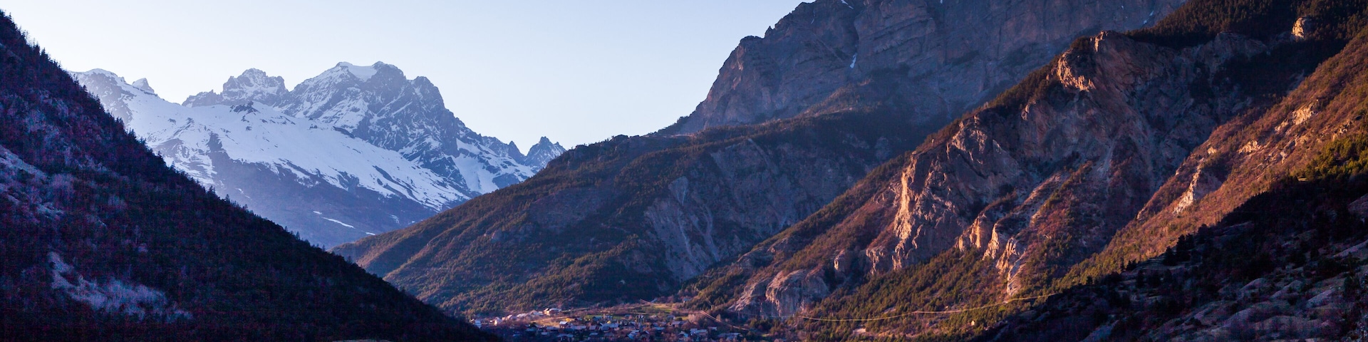 Un paisaje montañoso con un pueblo enclavado en un valle.