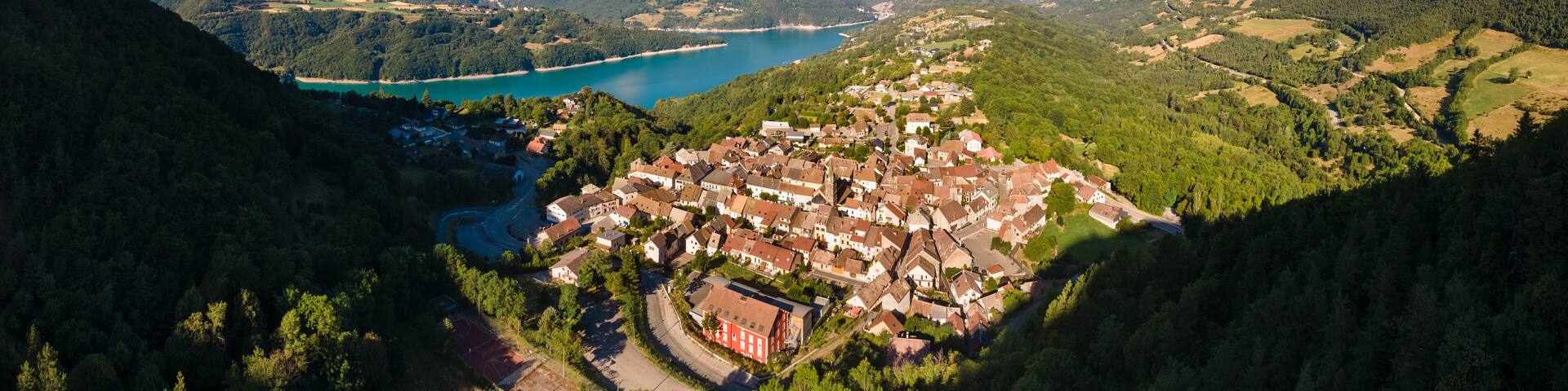 Aerial view of the village of Corps with Sautet Lake. In the distance, the higest point in Devoluy mountain range, the Obiou peak. Isere, Alps, France