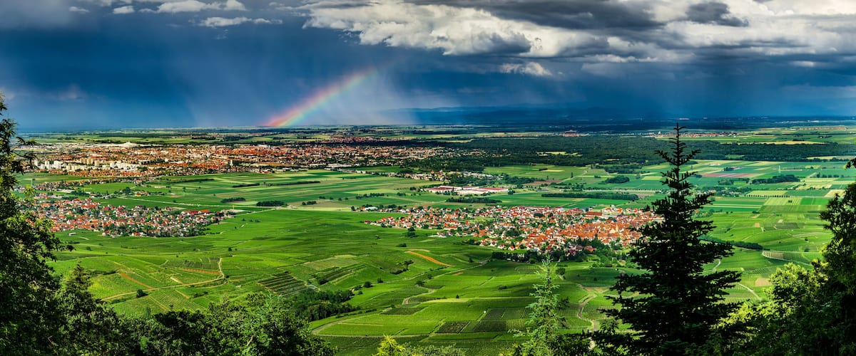 Aerial panoramic view of the rainbow over the green valley, drone shooting