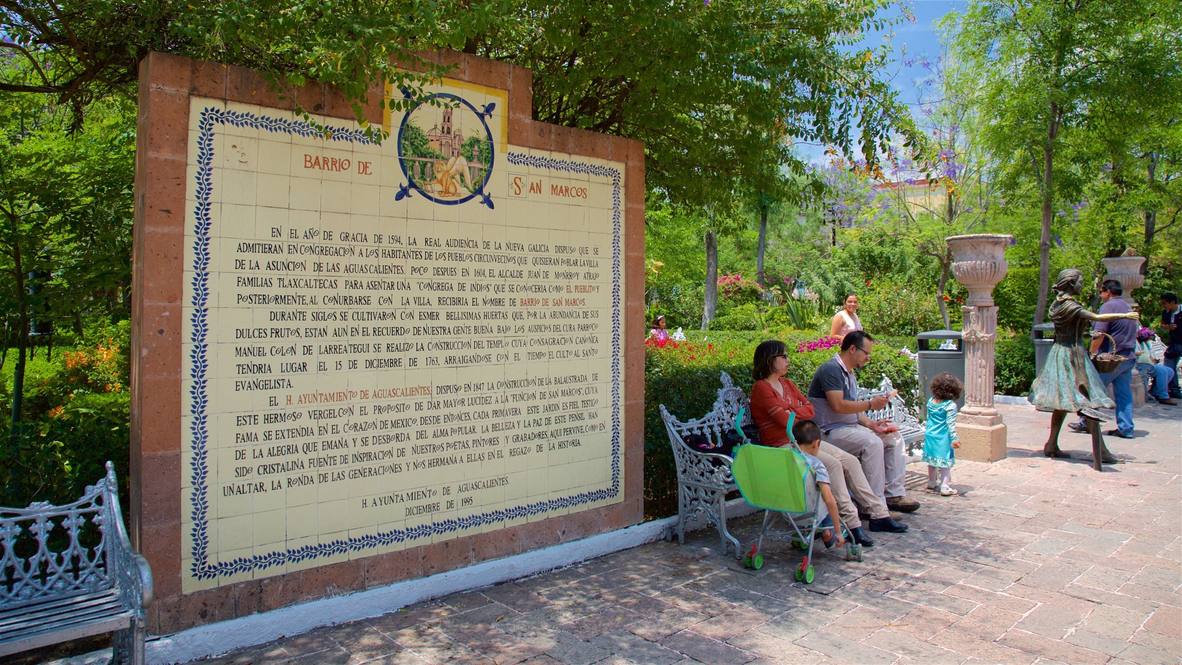 San Marcos trädgård som inkluderar skyltar och en trädgård såväl som en familj