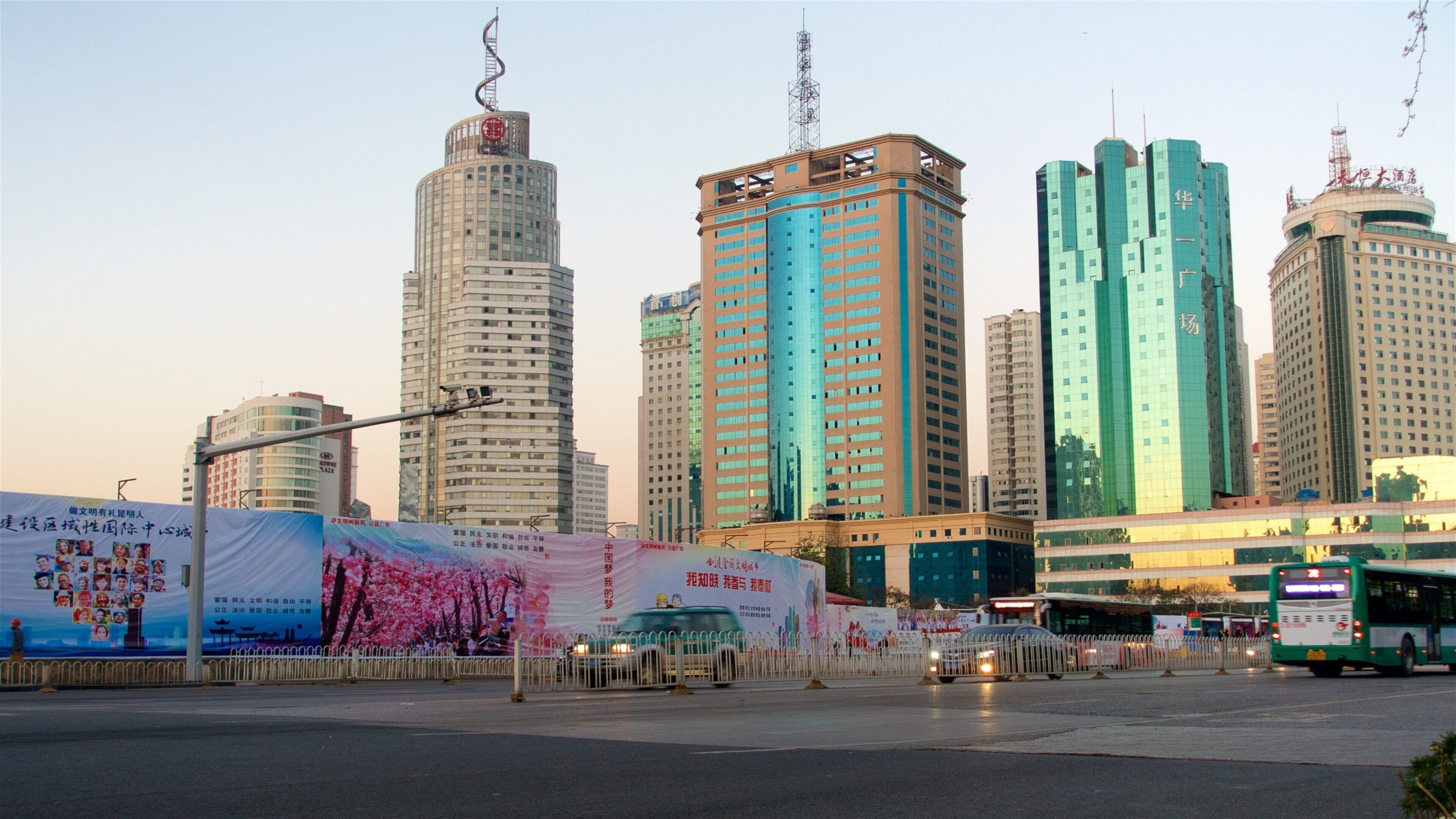Kunming which includes a city, a high-rise building and a sunset
