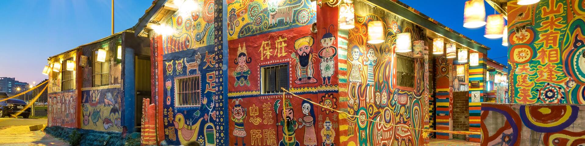 A brightly painted building with intricate murals and colorful lights.