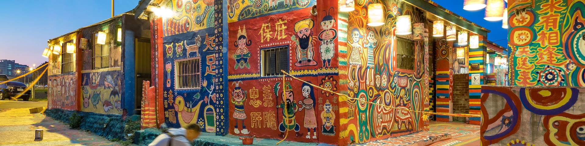 Um edifício ricamente pintado com murais detalhados e luzes coloridas.