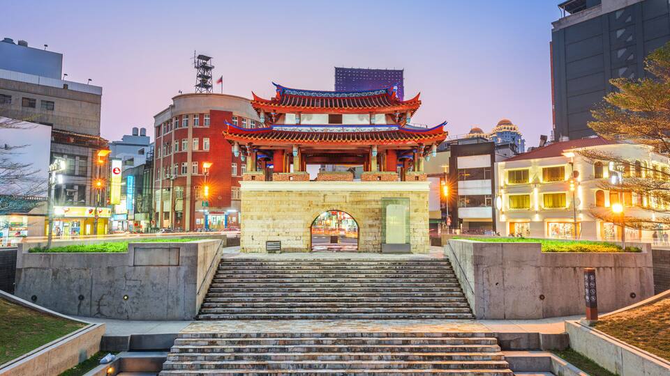 A traditional Chinese gate with ornate architecture, leading to a modern cityscape with contemporary buildings.