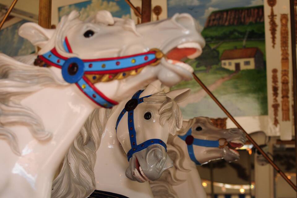 A carousel horse with a blue and red bridle.