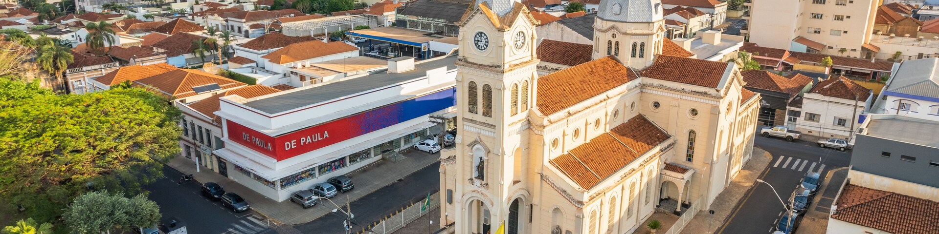 Un paisaje urbano con una iglesia destacada, un edificio moderno identificado como 'De Paula', y una zona residencial densa.