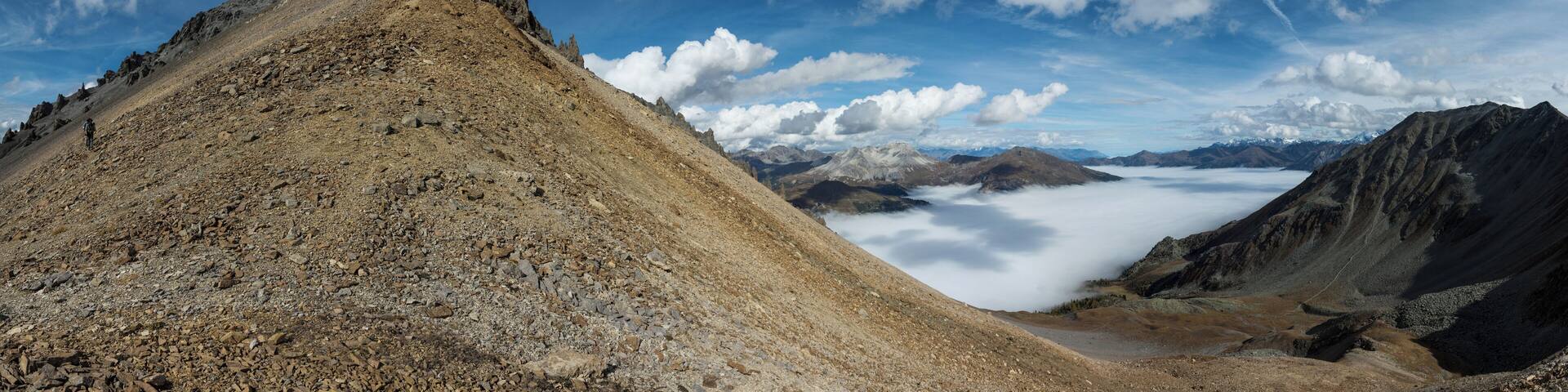 Biosfera Val Müstair- Piz Daint, Abstieg Richtung Süden bei Taunter Pizza, Blick zurück zum Gipfel, rechts die Wolken über dem Val Müstair