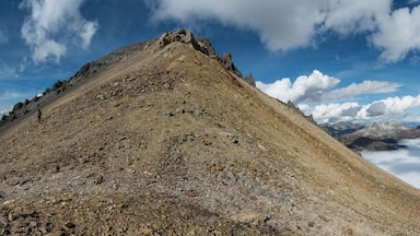 Biosfera Val MĂŒstair- Piz Daint, Abstieg Richtung SĂŒden bei Taunter Pizza, Blick zurĂŒck zum Gipfel, rechts die Wolken ĂŒber dem Val MĂŒstair