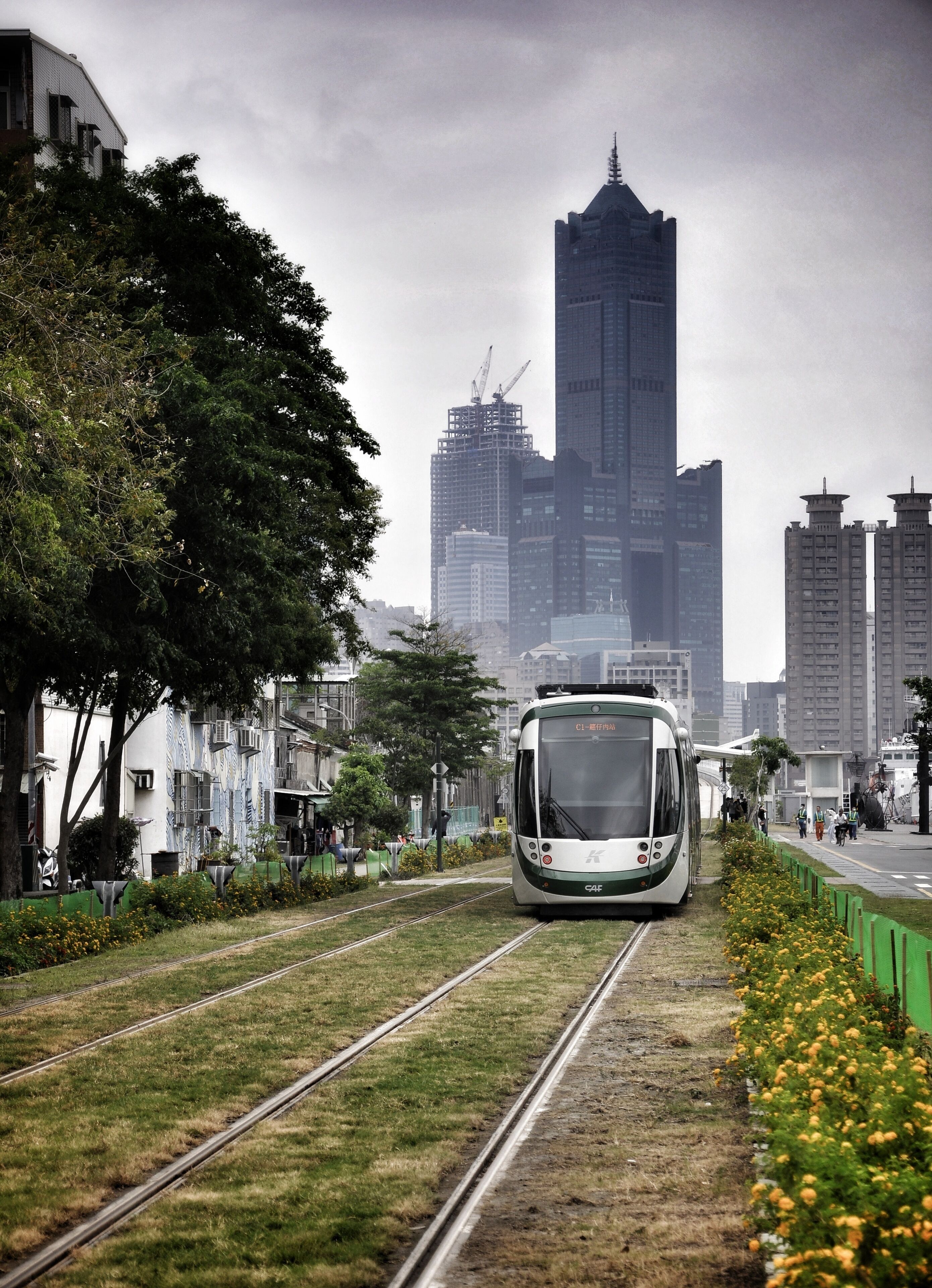 A train on tracks with a cityscape in the background.