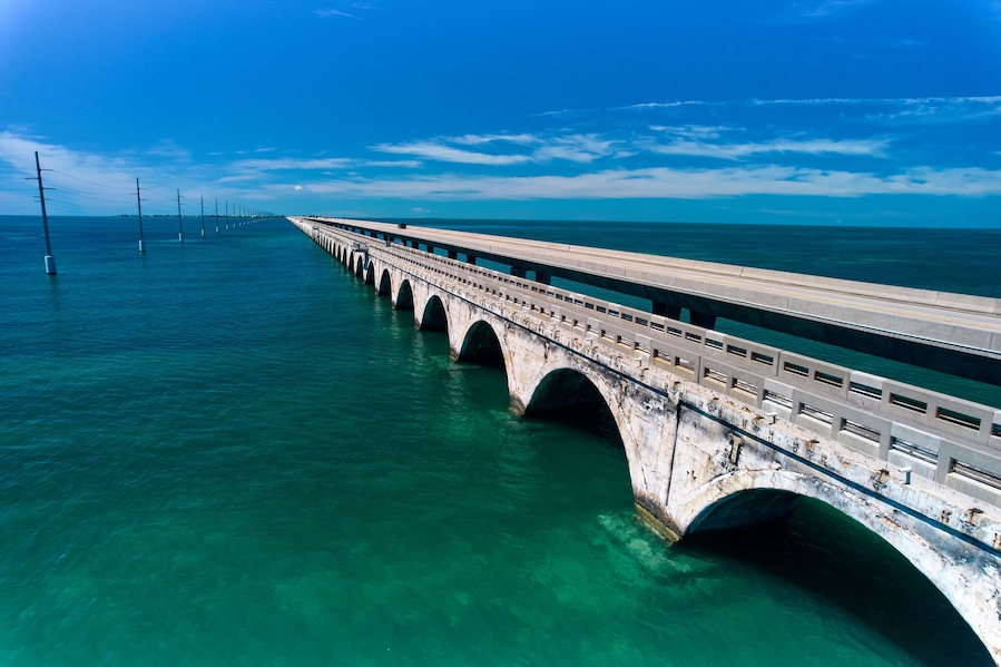 Un puente largo sobre aguas turquesas con cielo despejado.
