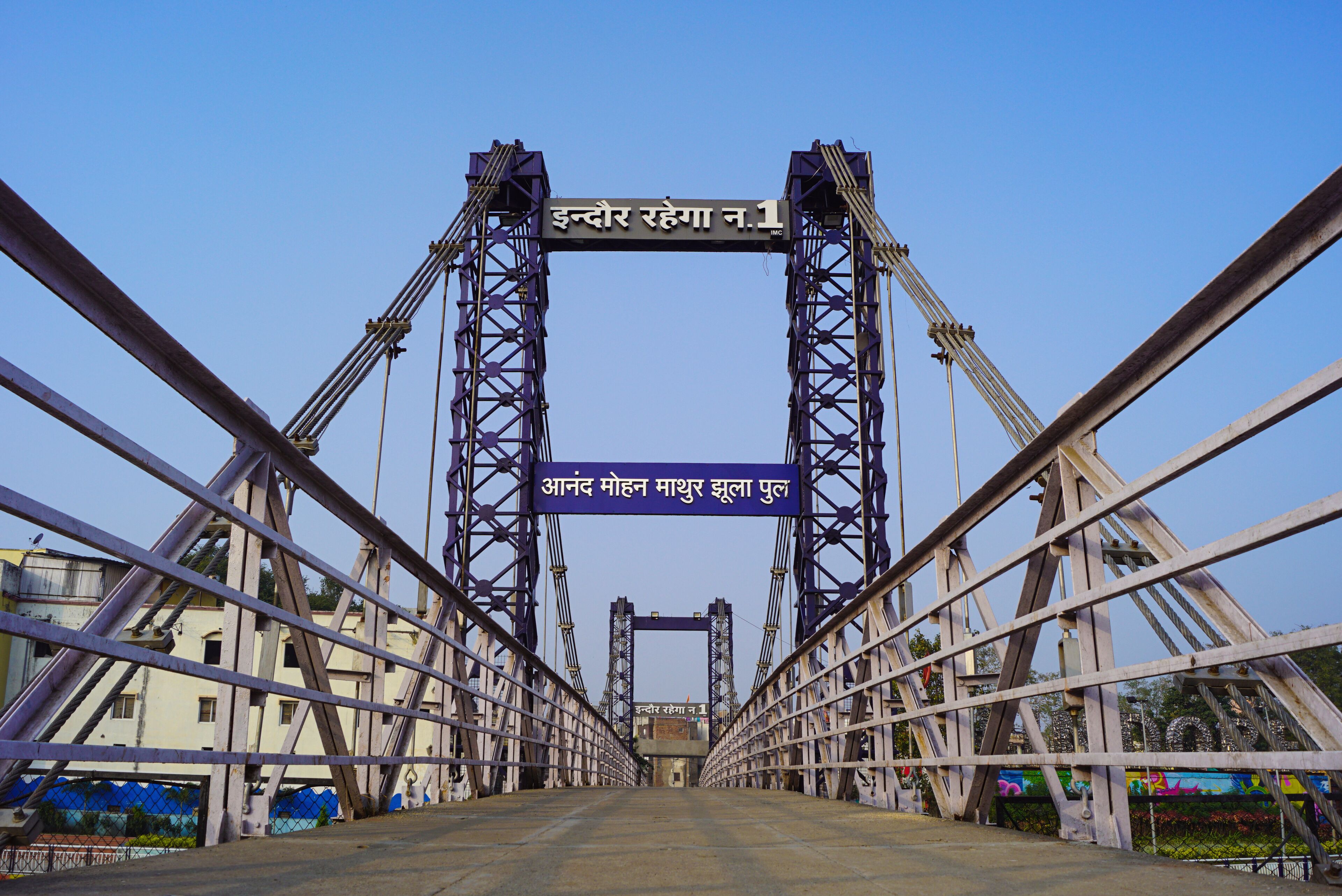 A bridge with two towers and a sign in Hindi.